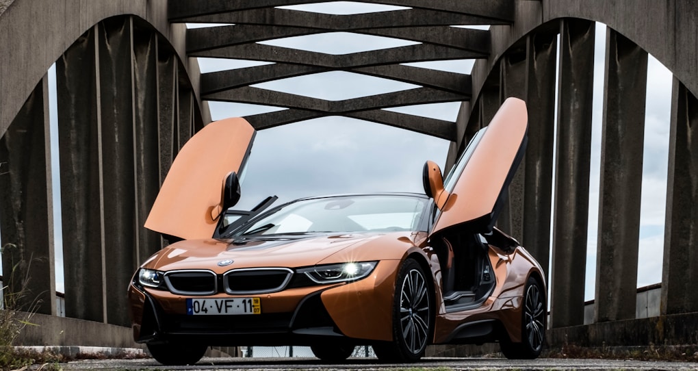 Top 10 Most Iconic BMW Models Ever Made 14 orange BMW i8 parked in middle of bridge