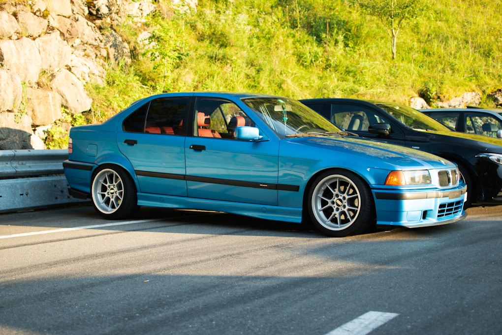 BMW 3 Series E36: The Last Cheap RWD Manual BMW Worth Buying? 2 A blue BMW E36 4-door sedan, parked on the side of the road