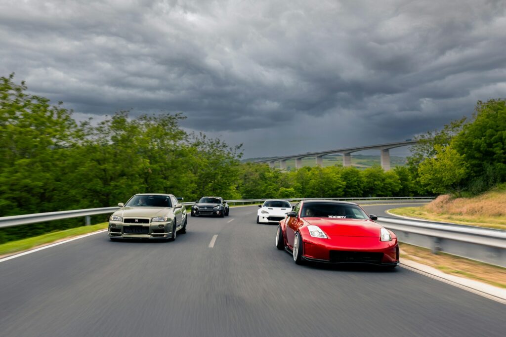 The Secret Codes Hidden in Your Car's VIN Number 2 Several cars driving on a winding road under stormy skies